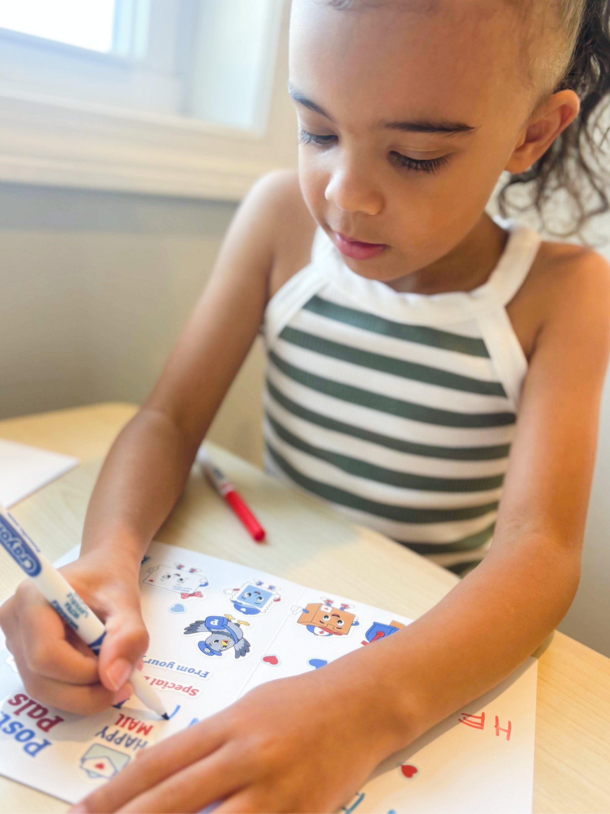 A young girl with a ponytail sits at a light wood desk, writing on a colorful activity sheet with a blue marker.