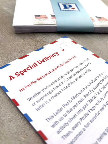 A close-up of a Postie Pals Letter Pad with a stack of bound envelopes by a light blue ribbon in the background.